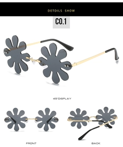 Detail view of flower-shaped rimless sunglasses with grey lenses and gold metal temples