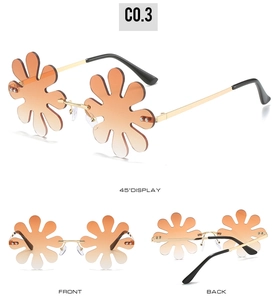 Detail view of daisy-shaped rimless sunglasses with orange gradient lenses and gold frame