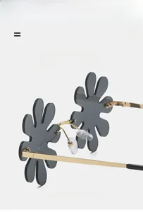 Detail of floral frameless sunglasses featuring smoke lenses and gold metal temples