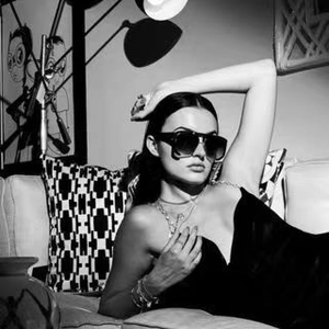 Close-up of retro oversized punk sunglasses on a model in a high-fashion black and white set