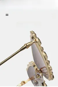 Détail de charnière dorée et strass marron brillants sur les lunettes œil de chat