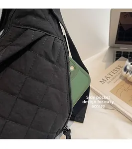 Dettaglio della tasca laterale con zip di una borsa a tracolla trapuntata nera