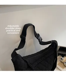 Dettaglio della tracolla regolabile e fibbia in plastica su borsa in nylon trapuntata
