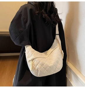 Dettaglio della borsa a tracolla in nylon trapuntato con motivo a rombi e zip intrecciata
