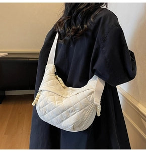 Dettaglio della borsa hobo in nylon bianco con trapuntatura a rombi e tracolla