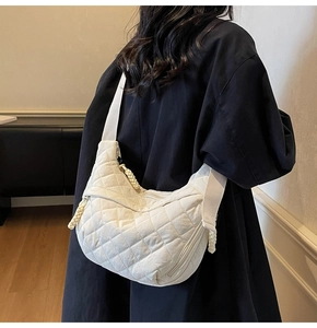 Dettaglio di una borsa a tracolla in nylon trapuntato bianco con motivo a rombi cuciti