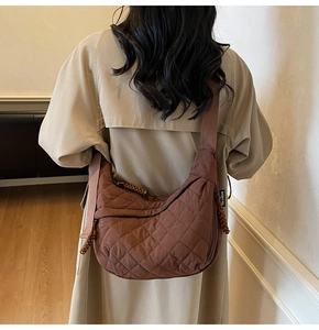 Borsa a tracolla in nylon trapuntato marrone abbinata a un trench coat neutro