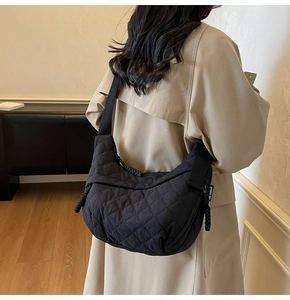 Dettaglio della borsa a mezzaluna trapuntata nera con tracolla e trama in nylon