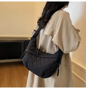 Dettaglio della borsa a tracolla in nylon nero trapuntato con cuciture a diamante e cinturino