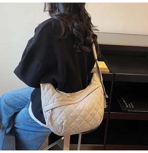 Dettaglio macro di una borsa hobo in nylon trapuntato grigio chiaro con zip intrecciata