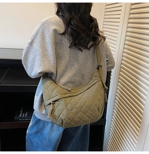 Dettaglio borsa a mezzaluna in nylon trapuntato verde militare con zip intrecciata