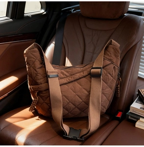 Dettaglio della borsa hobo trapuntata in nylon marrone su sedile in pelle