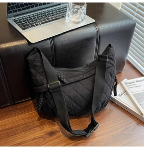 Dettaglio della borsa a mezzaluna in nylon trapuntato nero con tracolla regolabile