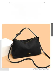 Detail of black faux suede shoulder bag with elegant gold hardware and sturdy handle