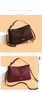 Detail view of suede underarm bags in dark brown and wine red with gold zipper