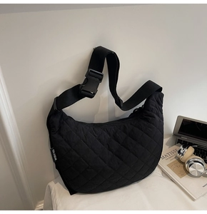 Dettaglio della borsa a mezzaluna in nylon nero trapuntato con tracolla regolabile