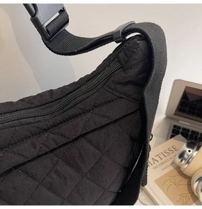 Dettaglio della borsa trapuntata in nylon nero con fibbia resistente e chiusura a zip