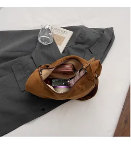 Dettaglio della grande capacità interna della borsa hobo in pelle scamosciata marrone con zip