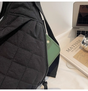 Dettaglio della tasca laterale con cerniera di una borsa in nylon trapuntata nera