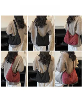 Dettaglio della borsa a tracolla in tela con tirazip intrecciati nei colori nero e bordeaux