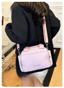 Close-up of pink multi-pocket tote bag with wide strap and silver metal logo detail