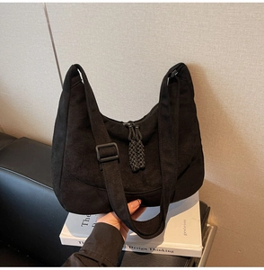Dettaglio borsa hobo nera con tracolla regolabile e tiretto della cerniera intrecciato