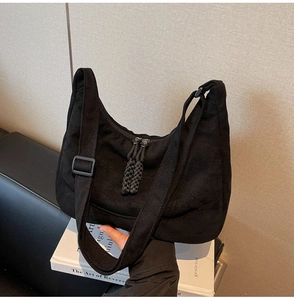 Dettaglio borsa hobo in velluto nero con tirante della cerniera in corda intrecciata