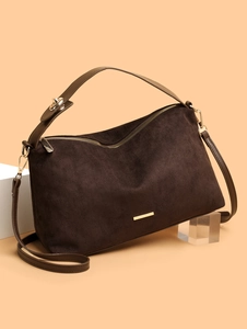 Deep coffee suede tote bag with golden hardware displayed on modern geometric stands