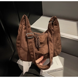 Dettaglio della borsa tote in pelle scamosciata con tracolla larga e fibbia opaca