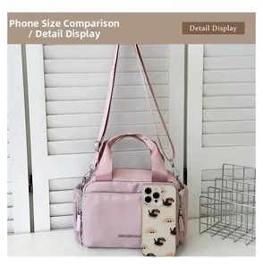 Detailed view of pink nylon tote bag with metal logo and front zipper pocket detail