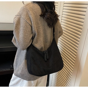 Dettaglio della borsa hobo nera opaca con tiretti della zip in corda intrecciata