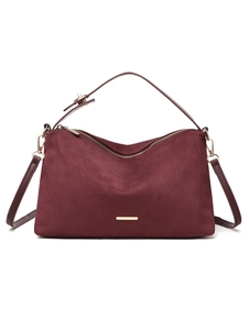 Detail view of burgundy faux suede bag with premium gold hardware and polished metal logo
