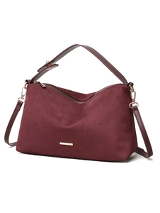 Close-up of burgundy suede shoulder bag with gold metal plaque and premium matte texture