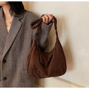 Dettaglio borsa hobo in pelle scamosciata marrone scuro con tracolla spessa e zip