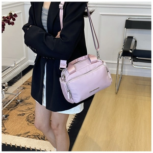 Detail of light purple nylon tote bag featuring multi-pocket design and adjustable strap