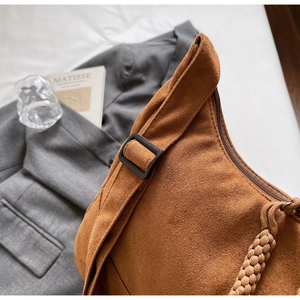 Dettaglio borsa hobo in camoscio caramello con fibbia nera e cordino intrecciato