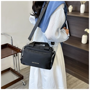 Detail of black nylon tote with multi-zipper pockets and adjustable wide strap