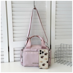 Pink nylon tote bag detail with Gentlewoman logo, multi-pocket design and strap