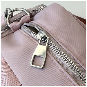 Detail of pink nylon tote bag with silver metal zipper and D-ring buckle