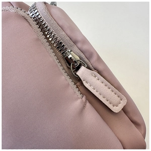 Detail of silver metal zipper and faux leather puller on the pink nylon tote bag
