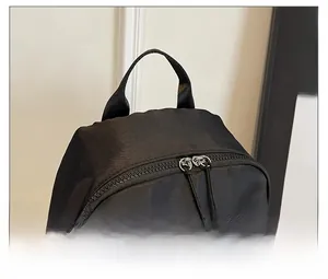 Detail of high-density black nylon backpack with dual-way zippers and top handle