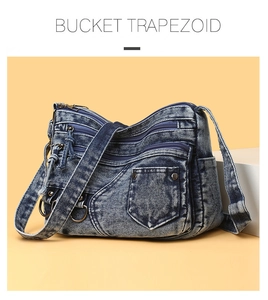 Detail of washed denim crossbody bag showing multi-layer zippers and retro metal hardware