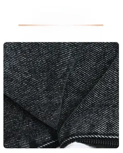 Close-up of durable black denim fabric texture and sturdy zipper on crossbody bag