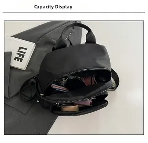 Interior view showing the large capacity of the black nylon mini backpack with essentials