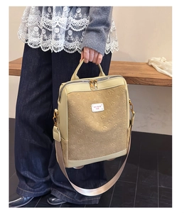 Dettaglio zaino beige con goffratura a stella e ampia tracolla in tessuto