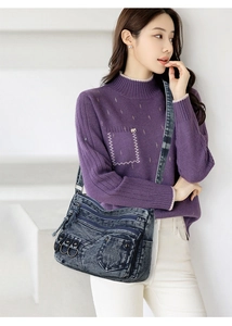 Detail view of washed denim crossbody bag featuring multiple pockets and metal ring accents
