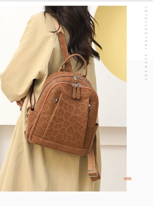 Rear view of a model wearing the brown leopard print backpack with adjustable straps