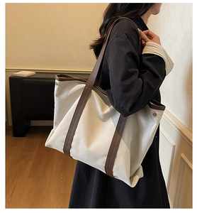Gros plan d'un grand sac cabas en toile avec anses en cuir brun et boucle métallique