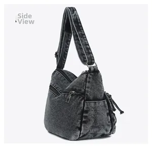 Side view of washed denim crossbody bag showing side zipper and wide shoulder strap