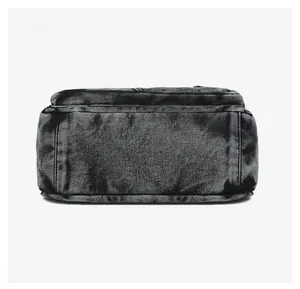 Detailed close-up of the reinforced bottom of this large washed denim crossbody bag